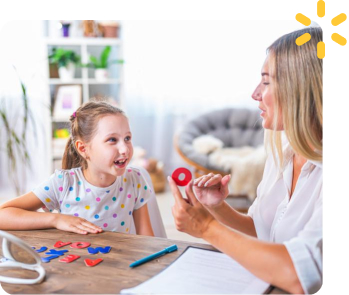 A young child and a BCBA playing with toys together during center-based ABA therapy
